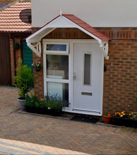 White front door with an external door canopy fitted on a brick house exterior