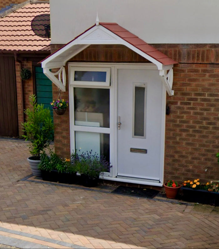 White front door with an external door canopy fitted on a brick house exterior